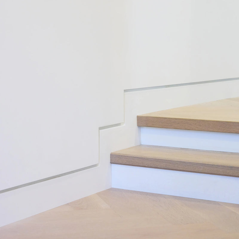 Recessed shadow gap baseboard where the wall runs straight to the floor